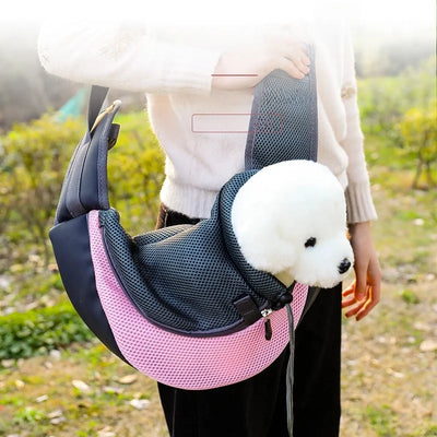 Aviour hands-free pet carrier bag in pink and black with mesh front carrying a small white dog outdoors