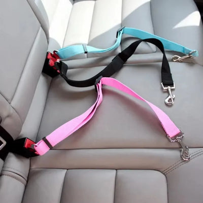 Aviour dog car seat belt for travel in pink, black, and blue attached to car seatbelt buckles